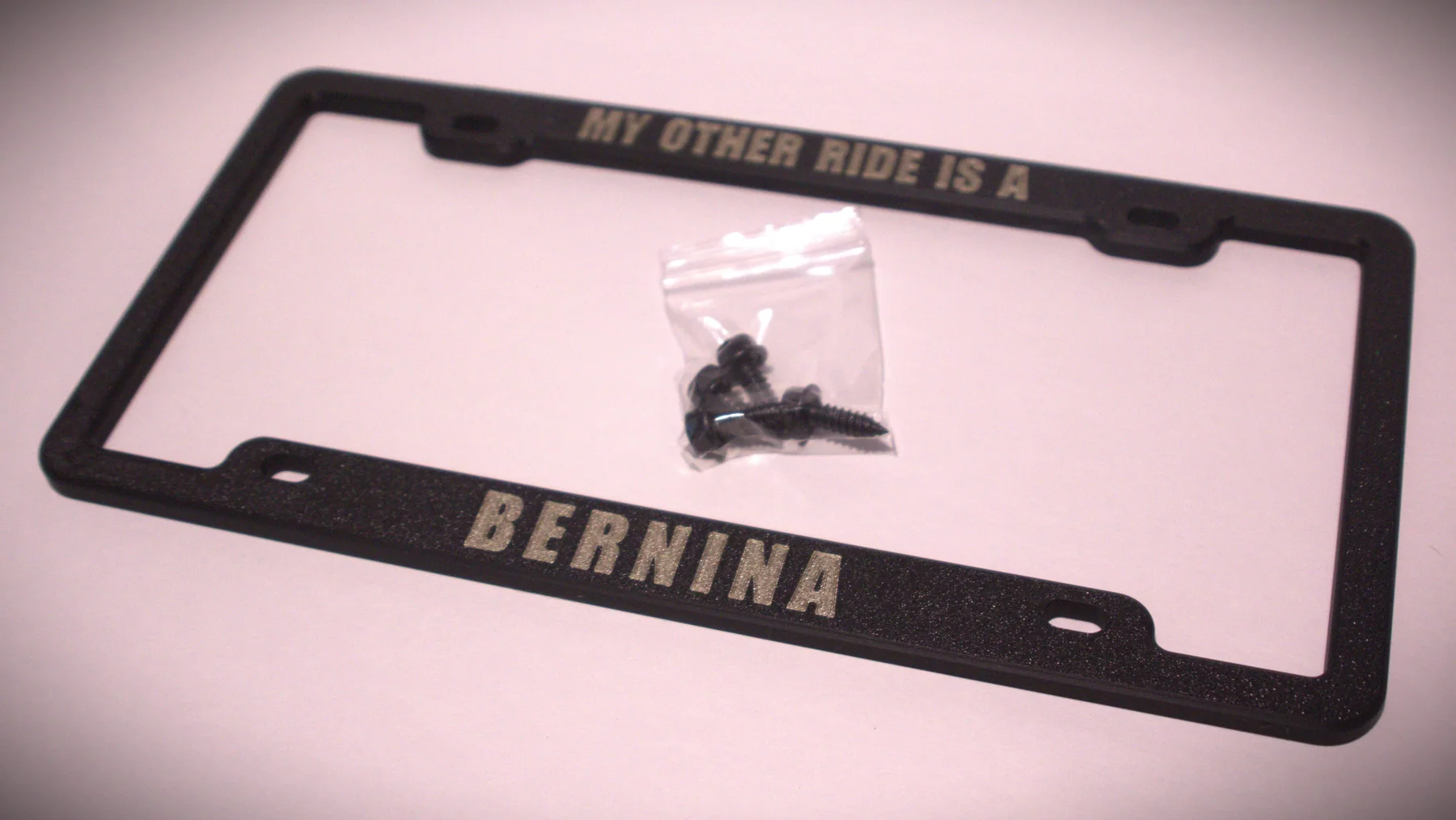 Two KT-34 standard personalized license plate frame examples with mounting hardware